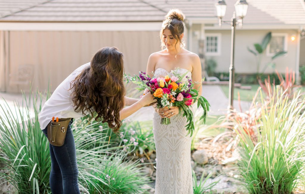 Lead Designer and florist of CH&LER touches up a bold and bright bridal bouquet